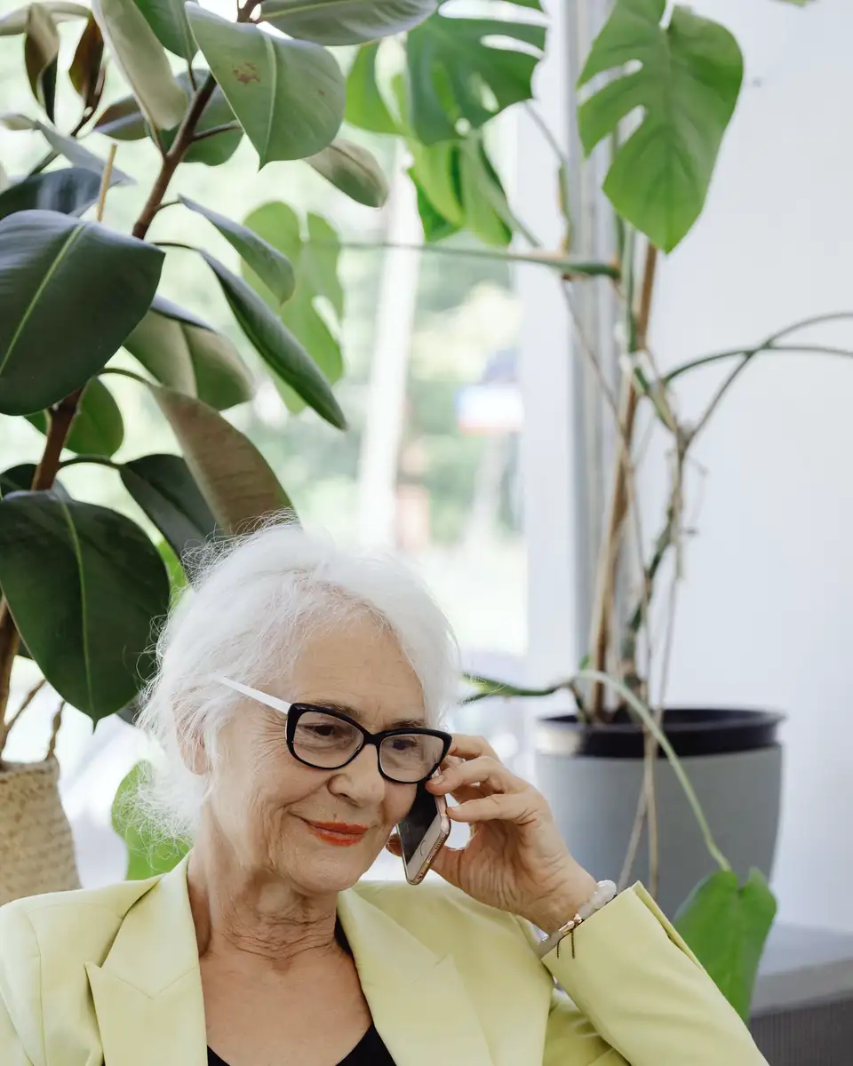 Older woman smiling among house plants