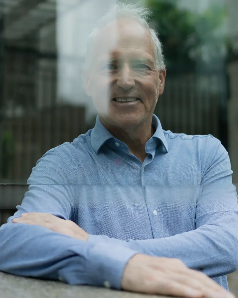 Older man smiling through a window