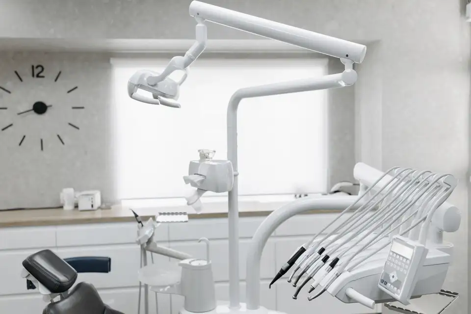 A bright treatment room with a dental chair and instruments by a window