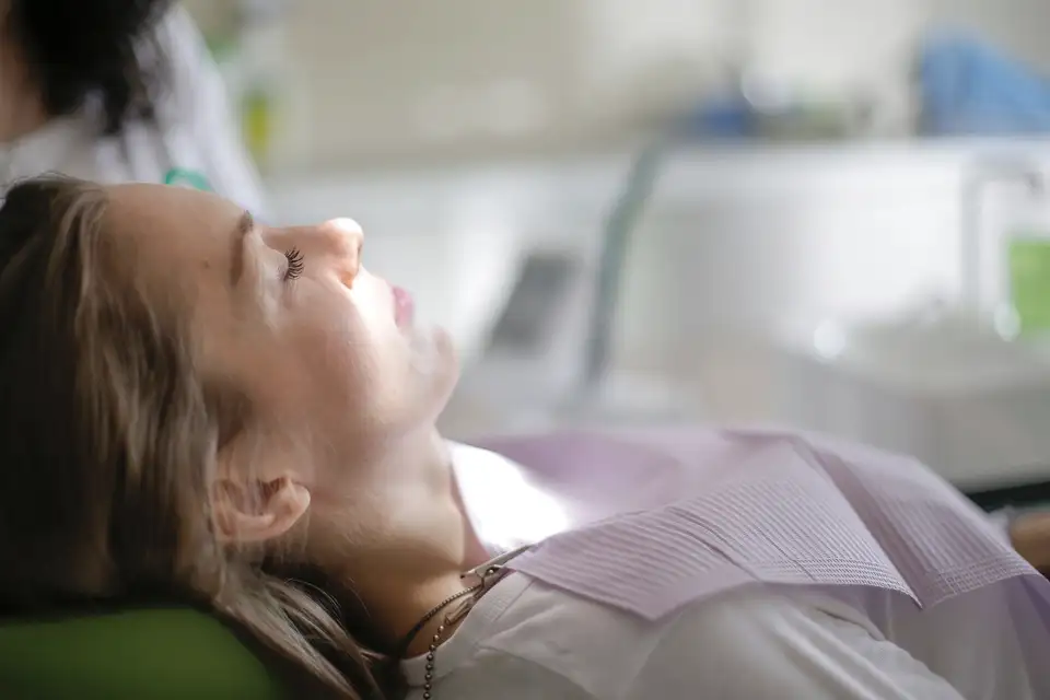 Patient resting calmly in a dental chair with eyes closed
